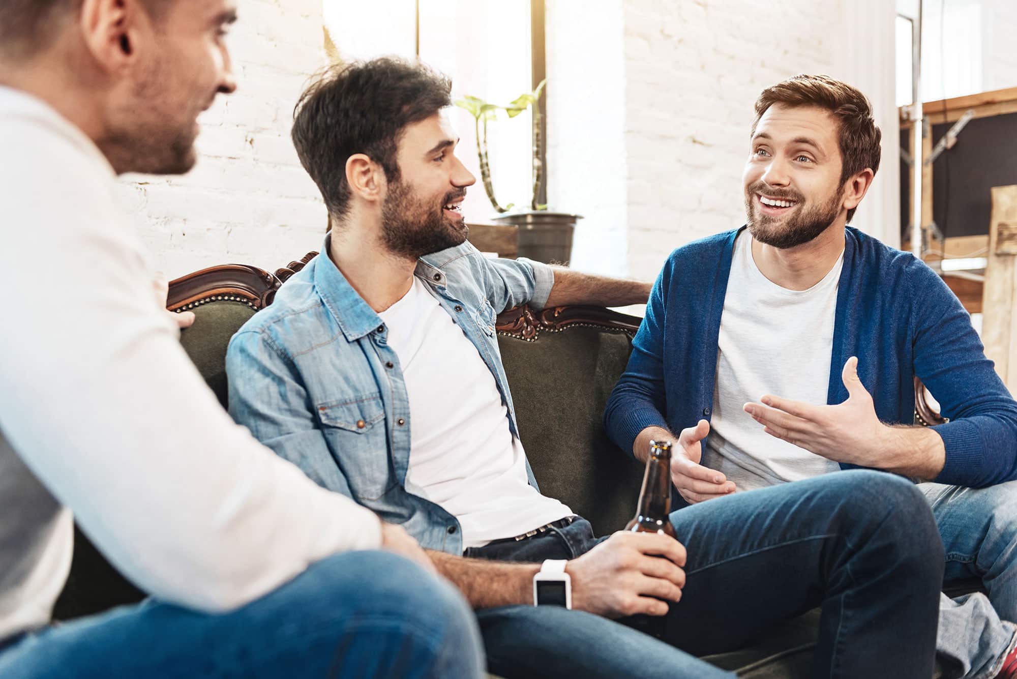 3 men on a couch talking